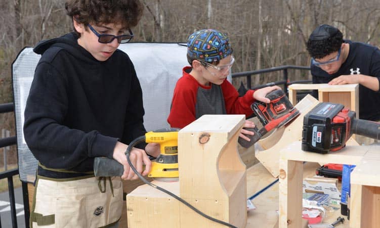 tuition-page CJDS boys working on building with wood